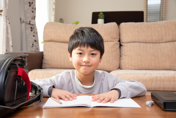 日本男孩放学回家，在客厅里做作业图片下载
