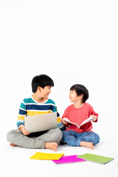 快乐亚洲男孩的肖像，兄弟在地板上笔记本电脑和书本孤立的白色背景，教育和学习的技术概念图片下载