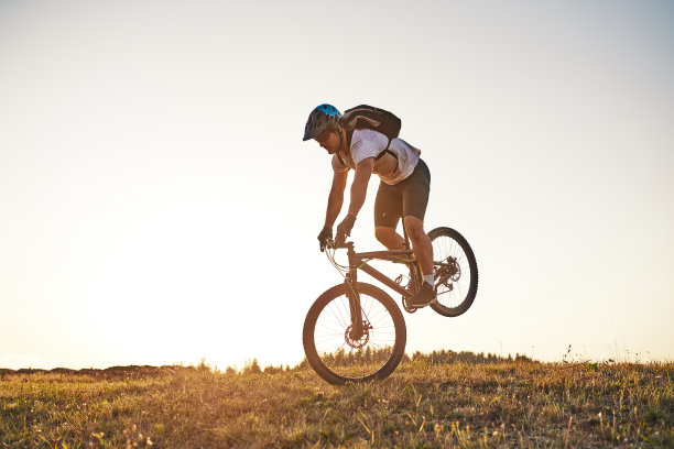 骑自行车的人在森林的小道上骑自行车。男子骑自行车在耐力越野赛道。运动健身的动力和灵感。极限运动的概念。有选择性的重点图片下载
