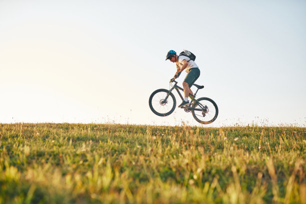 骑自行车的人在森林的小道上骑自行车。男子骑自行车在耐力越野赛道。运动健身的动力和灵感。极限运动的概念。有选择性的重点图片下载