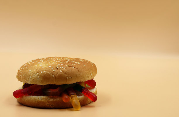 用软糖豆做的汉堡包，在浅橙色的背景上为拷贝留出空间图片下载