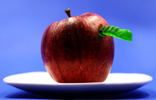 绿色软糖虫从红苹果里爬出来图片下载