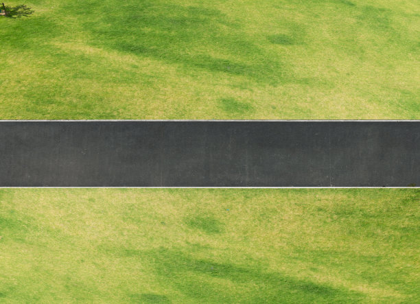 俯瞰着穿过绿色草坪的柏油路图片下载