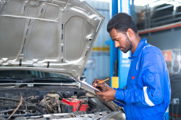汽车修理工在车库开式汽车发动机维修时注意维修零件-客户报告的理念，专业的工人和维修服务。图片下载