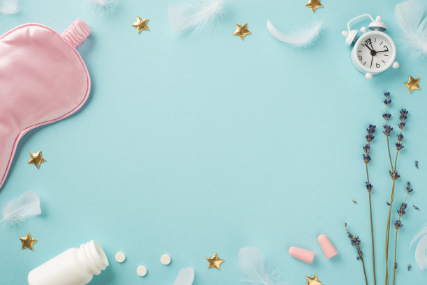 俯视图照片薰衣草羽毛小白色闹钟粉红色丝绸睡眠面具耳塞开瓶与药丸和金色星星在孤立的淡色蓝色背景与copyspace在中间图片下载