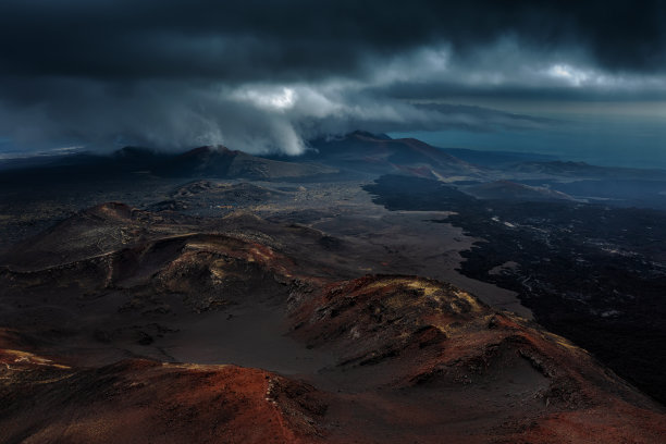 俄罗斯堪察加半岛托尔巴奇克火山附近的黑色熔岩田。暴风雨天空下的夏日景观。图片下载