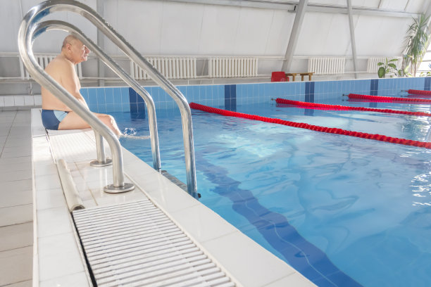 一位老人在一个退休的运动中心的游泳池里积极地从事游泳和运动。图片下载