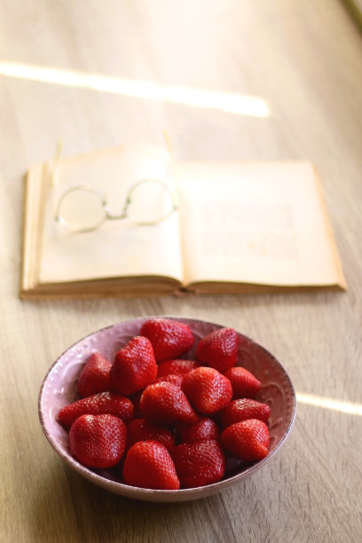 一碗草莓，打开的书和阅读眼镜图片下载