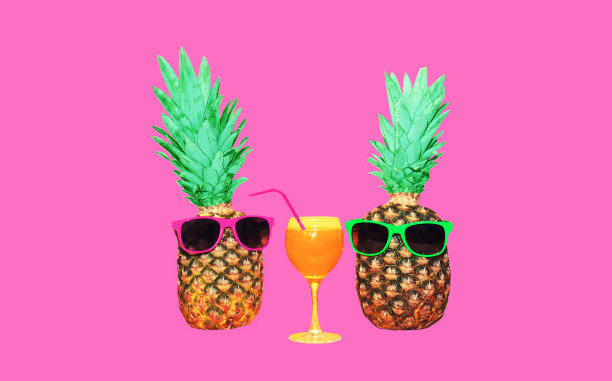 有趣的菠萝太阳镜与果汁在粉红色的背景图片下载