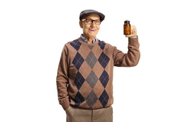 一位老人拿着一瓶药，面带微笑图片下载