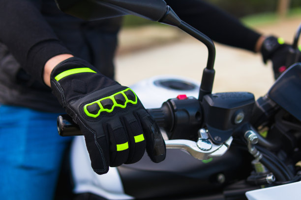一个戴着手套的男人的手放在摩托车的方向盘上图片下载