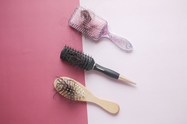 俯视图的刷子与丢失的头发在桌子上图片下载