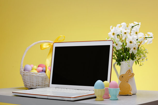 一个空白屏幕的笔记本电脑放在一张为复活节节日装饰的桌子上图片下载