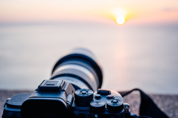 阳台上放置了相机，捕捉美丽的自然海景和山景，日落的场景。有选择性的重点。图片下载