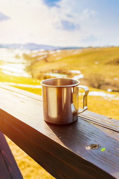 早晨的咖啡或茶在阳台上阳光明媚的山背景。副本的空间。春天的季节。旅游景观。热饮快感概念图片下载