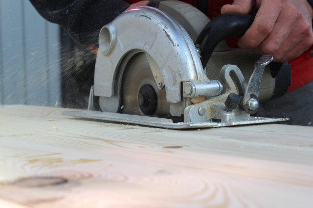 男子用电锯切割木板。图片下载