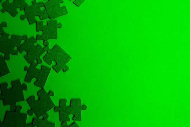 绿色的拼图放在桌子上，背景是绿色的。图片下载