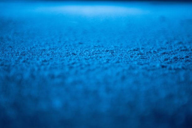 花样滑冰或曲棍球比赛场地冰面的低角度。冰背景和冰纹理与花样和划痕从溜冰鞋切割。蓝色灯光下的纹理冰与雪的细节。近距离图片下载