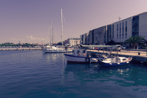 一艘船和一艘豪华游艇停泊在港口的照片。美丽的地中海港口照片图片下载