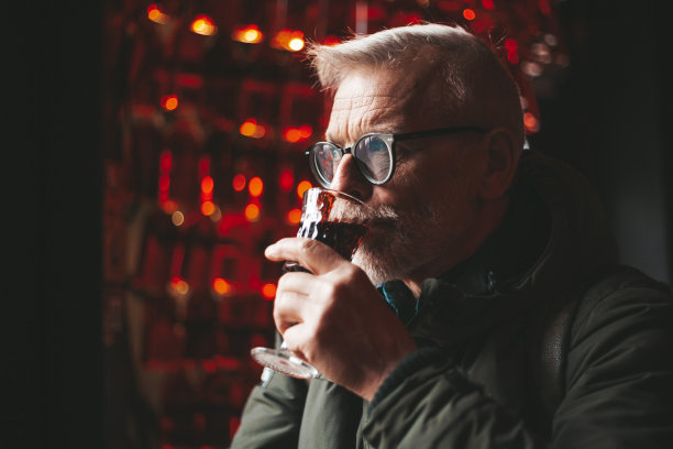 在酒吧里喝着酒的老男人。酒的香气。图片下载