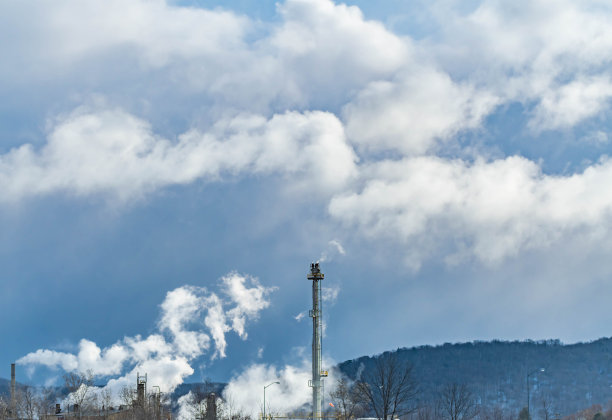 云背景上的石油钻塔着火燃烧。图片下载