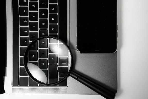 电脑，手机和放大镜在白色背景板上图片下载