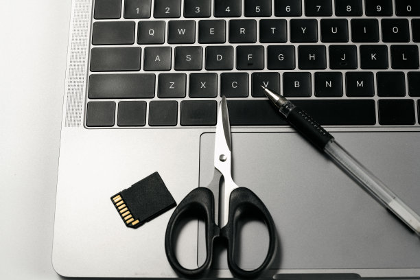 电脑，钢笔和剪刀在白色背景板图片下载