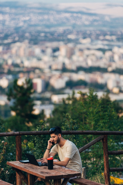年轻员工在户外使用笔记本电脑和数码平板电脑图片下载