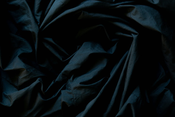 黑色起皱织物表面，近起皱的黑色织物床单纹理背景。图片下载