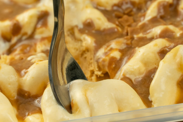 用甜点勺舀焦糖冰淇淋的特写镜头。焦糖冰淇淋的微距摄影。图片下载
