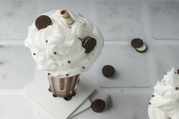 美味甜点的特写镜头。奶昔，巧克力和鲜奶油，饼干在一个高的杯子上的浅色背景。有选择性的重点图片下载