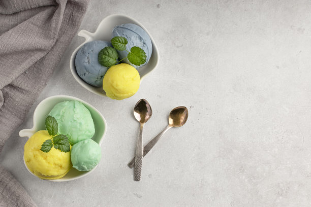 自制的天然产品。白色碗里的夏日冰淇淋口味，背景淡。清凉的夏日甜点，配以新鲜的薄荷。前视图。副本的空间。图片下载