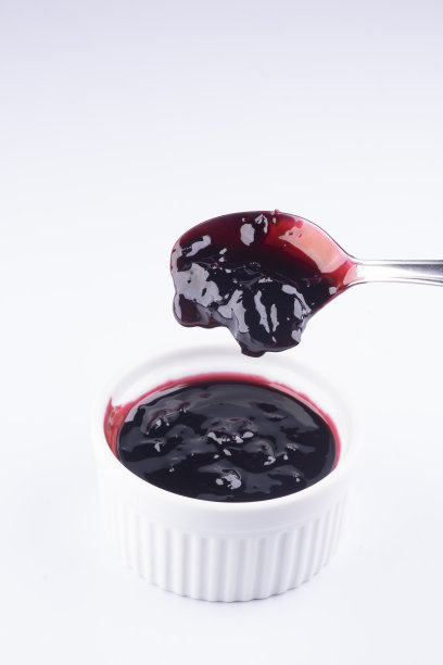 杂色-用汤匙将浆果果酱倒入白底色的罐子中图片下载