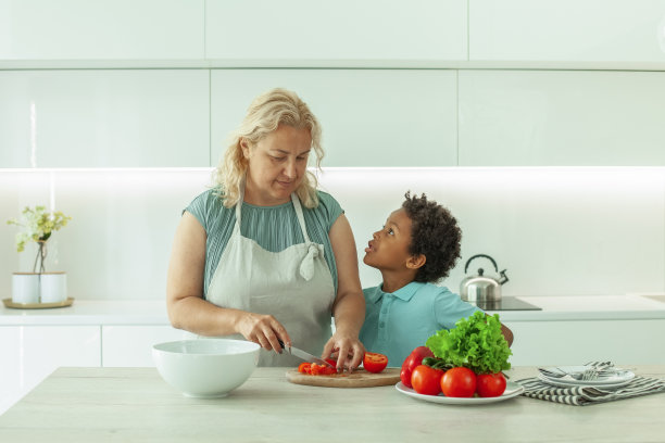 好奇的好管闲事的孩子和他的妈妈在厨房里图片下载