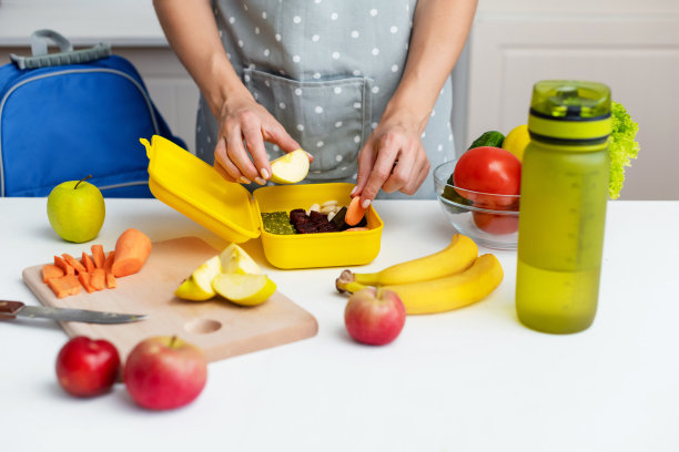年轻女子在早上为学校做健康午餐图片下载