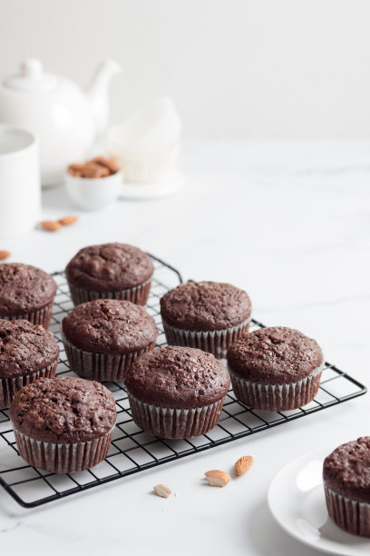 白桌上的格子上放着新鲜出炉的巧克力松饼图片下载