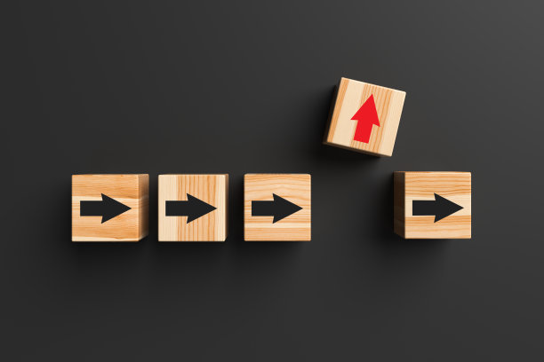 带箭头的木块从人群中脱颖而出，在黑色背景上向上移动。图片下载