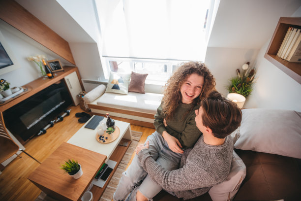 幸福的年轻夫妇在家里放松，在沙发上享受闲暇图片下载