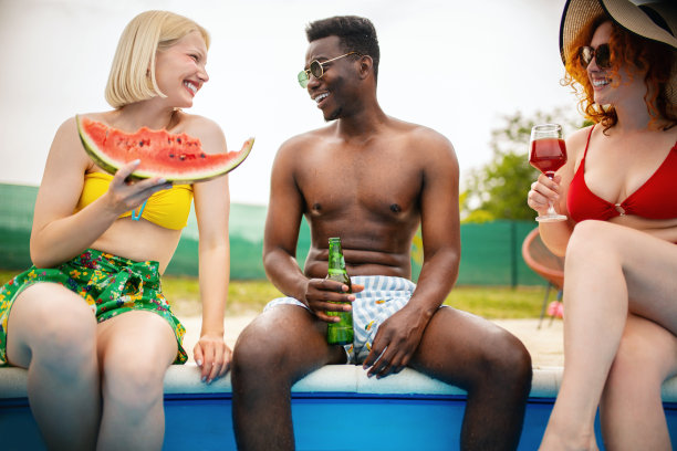 朋友们在泳池边享受。图片下载