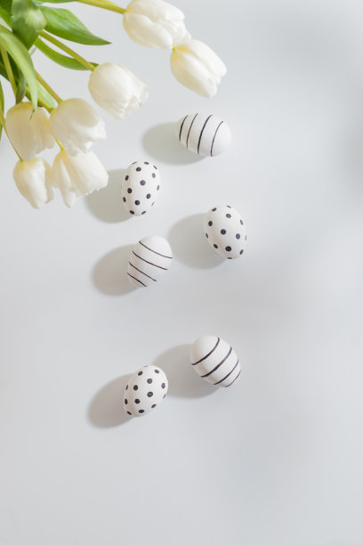 平坦的复活节构图与白色郁金香在一个花瓶和复活节彩蛋在一个浅色的背景图片下载