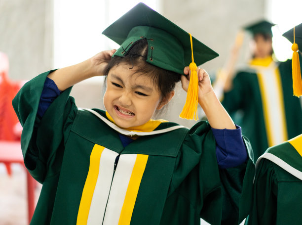 童年的学生和朋友们穿着毕业礼服图片下载