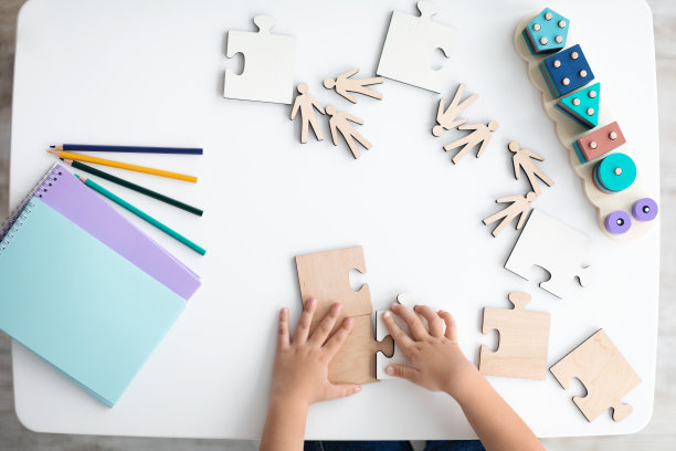 无法辨认的小孩在桌子上玩木制拼图，俯视图，自由空间图片下载