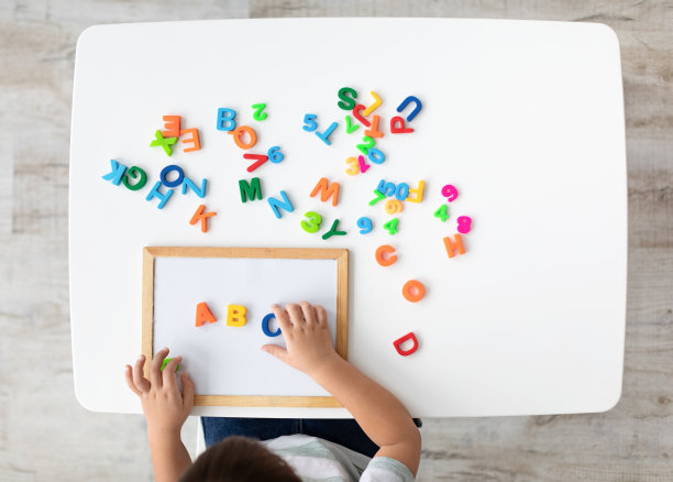 外语类。俯视图的孩子做ABC笔记与彩色英语字母，俯视图，空白的空间图片下载