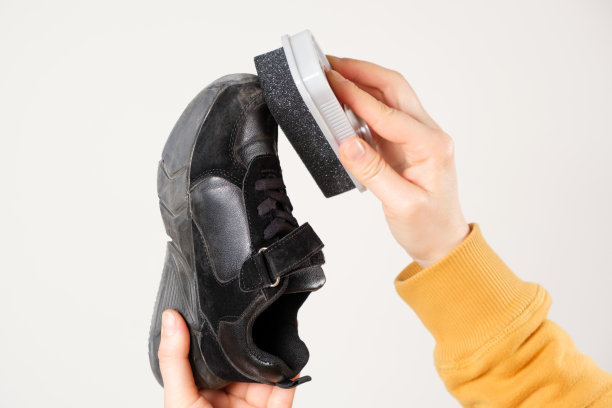 女人用海绵把奶精抹在孩子的黑色面包屑上。白色背景，特写镜头图片下载