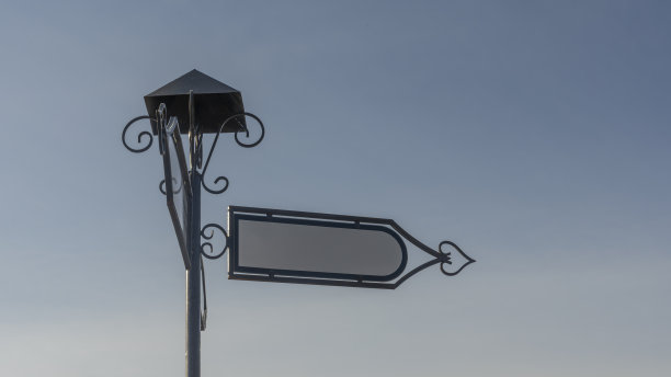 蓝色的天空衬托着老式的空白路牌。指示牌上的白色金属箭头。图片下载