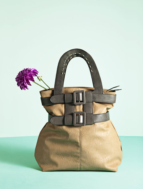 棕色皮革手袋与粉红色的单花图片下载