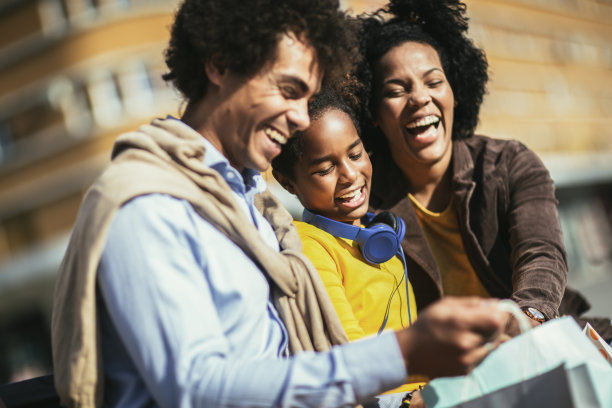 快乐的年轻夫妇和女儿一起购物。图片下载