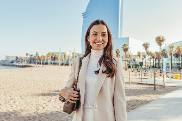 年轻开朗的女商人站在沙滩上盯着相机图片下载