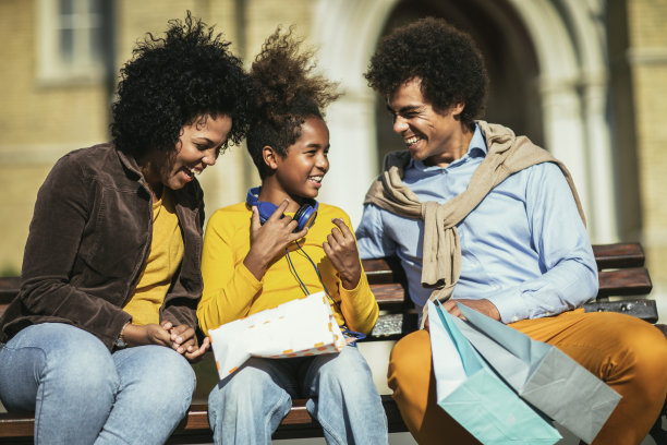 快乐的年轻夫妇和女儿一起购物。图片下载