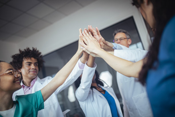 一群多种族的医生正在庆祝一个成功的病人手术。图片下载